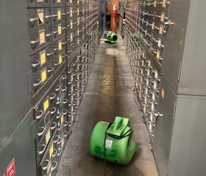 Air movers drying the wet warehouse aisle 