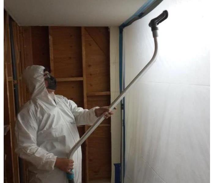 SERVPRO Employee HEPA vacuums inside a containment to remove any airborne mold spores. 